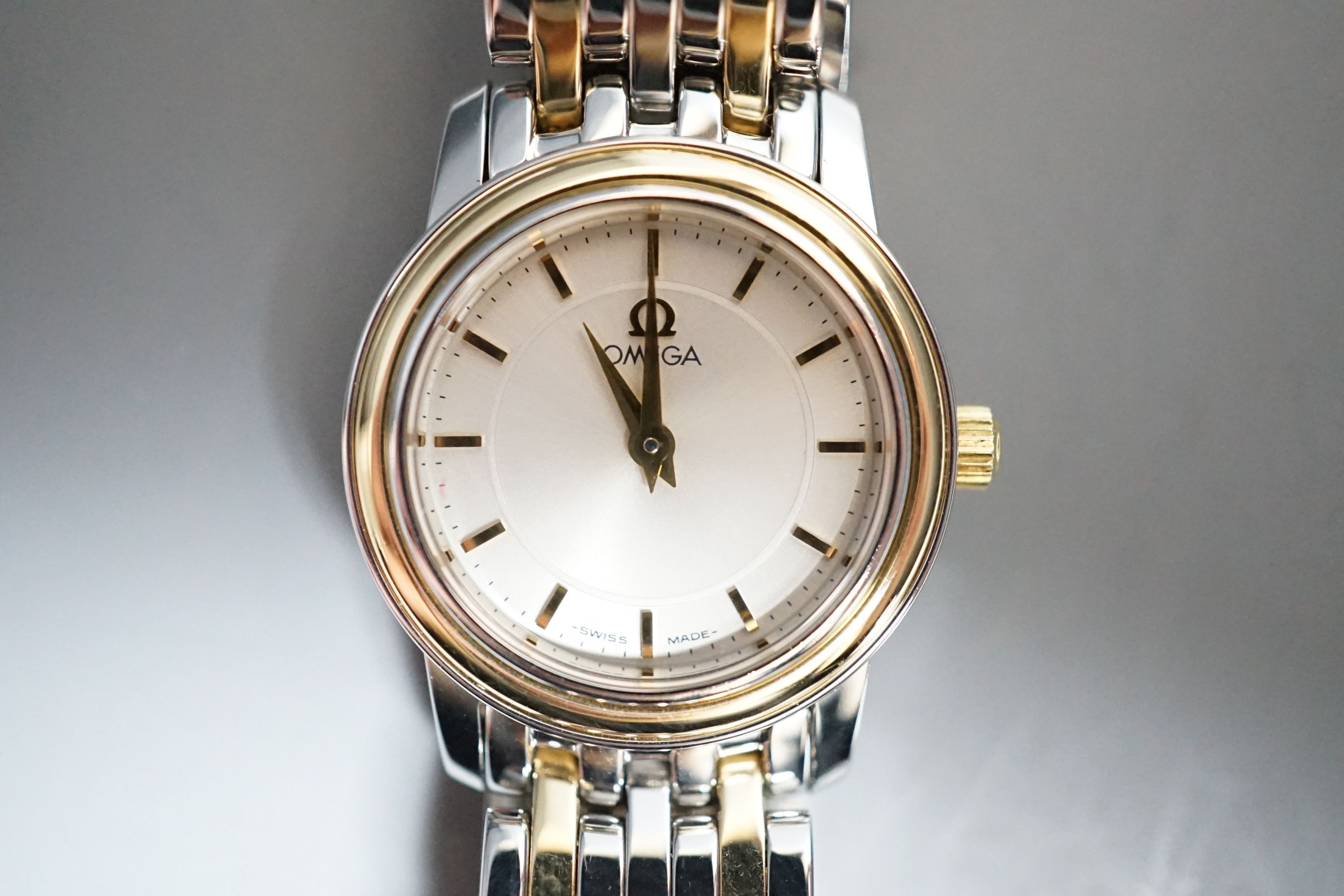 A lady's steel and gold plated Omega quartz wrist watch, on steel and gold plated Omega bracelet, with Omega carrying case.